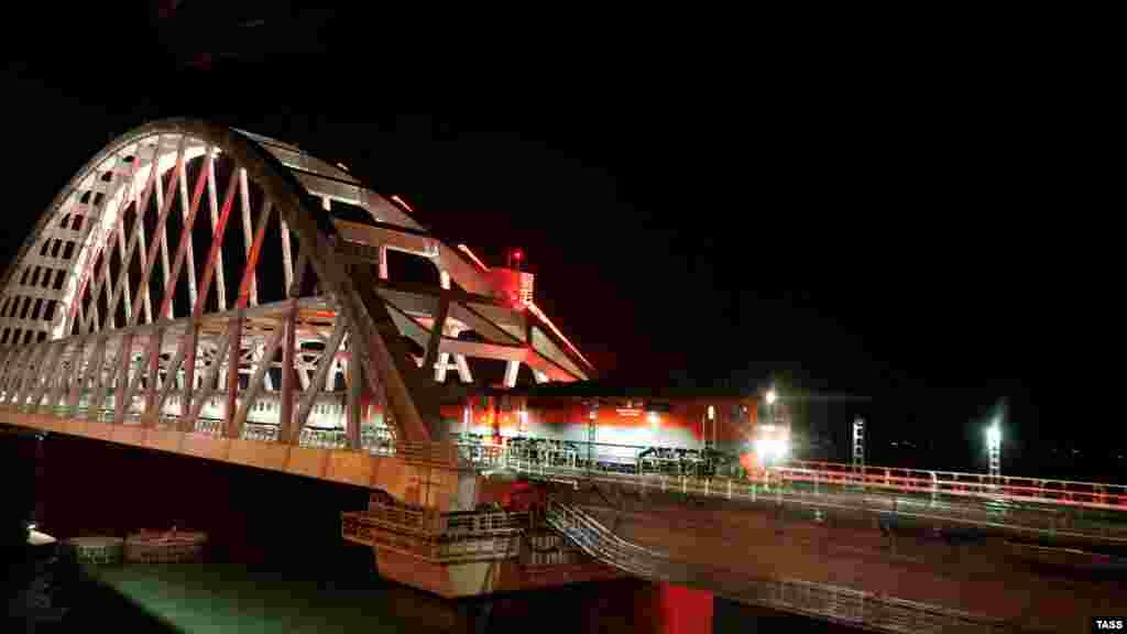 Российский пассажирский поезд «Таврия» на Керченском мосту 25 декабря. Движение по мосту открыл президент России Владимир Путин двумя днями ранее. МИД Украины выразило решительный протест в связи с его несогласованным визитом в аннексированный Крым и открытием движения по железнодорожной части Керченского моста, а Европейский Cоюз назвал это нарушением суверенитета и территориальной целостности Украины