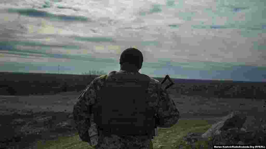 Солдат 30-ої окремої механізованої бригади йде у напрямку українських позицій. На горизонті – підтримувані Росією сепаратисти