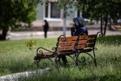 Пацієнтка лікарні на лавочці біля амбулаторного корпусу №11