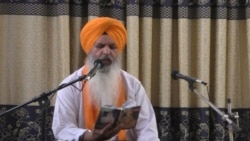 د سیکانو یو ګورو په ګوردواره کې د خپل سپېڅلي کتاب پاڼې لولي