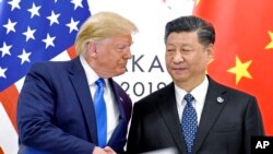 Președintele SUA Donald Trump (stânga), dă mâna cu președintele Chinei, Xi Jinping, la summitul G-20 de la Osaka, Japonia, 29 iunie 2019.