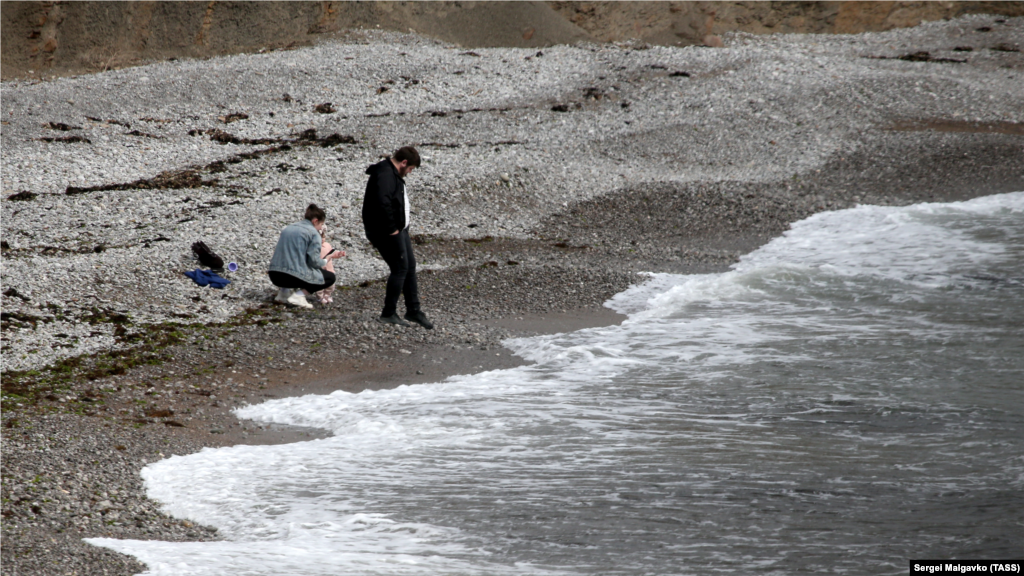 Семья отдыхает на пляже в бухте Капсель, неподалеку от Судака. Бухта Капсель входит в охранную зону памятника природы «Мыс Меганом»
