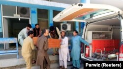 Afghan men carry the coffin of one of three female polio vaccination health workers shot and killed by unknown gunmen at two separate locations in Jalalabad on March 30.
