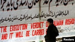 Мальчик читает на стене Тегеранского университета плакат, на котором написано: "Казнь Рушди будет приведена в исполнение"