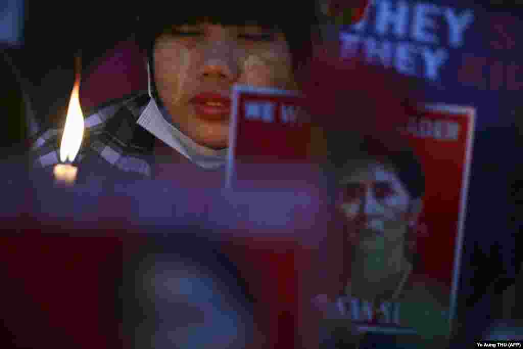 Протестувальниця тримає свічку в пам'ять про вбитих під час демонстрації проти військового перевороту на акції біля посольства США в Янгоні, М'янма, 21 лютого 2021 року