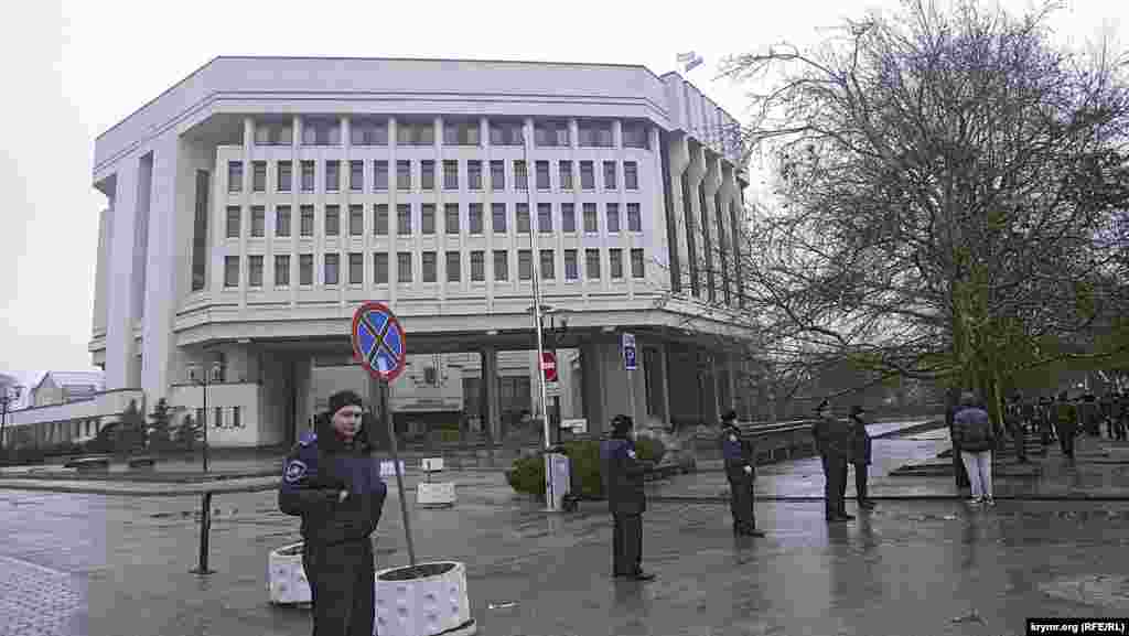 Около Верховной Рады, которая тоже была оцеплена милицией,  толпились человек 300 – 400 митингующих с флагами Автономной республики Крым и российскими полотнищами. Над зданием Верховной Ради тоже развевались два флага – флаг Крыма и российский триколор. Вчерашние баррикады стоят, но людей около них не видно