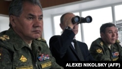 Президент Росії Володимир Путін, міністр оборони Сергій Шойгу (ліворуч) і начальник Генштабу Збройних сил РФ Валерій Герасимов (праворуч) спостерігають за військовими навчаннями у Росії, поблизу міста Чита в східному Сибіру, 17 липня 2013 року