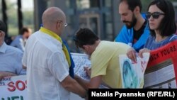 Перехожі підписують листівку до дня народження Сенцова