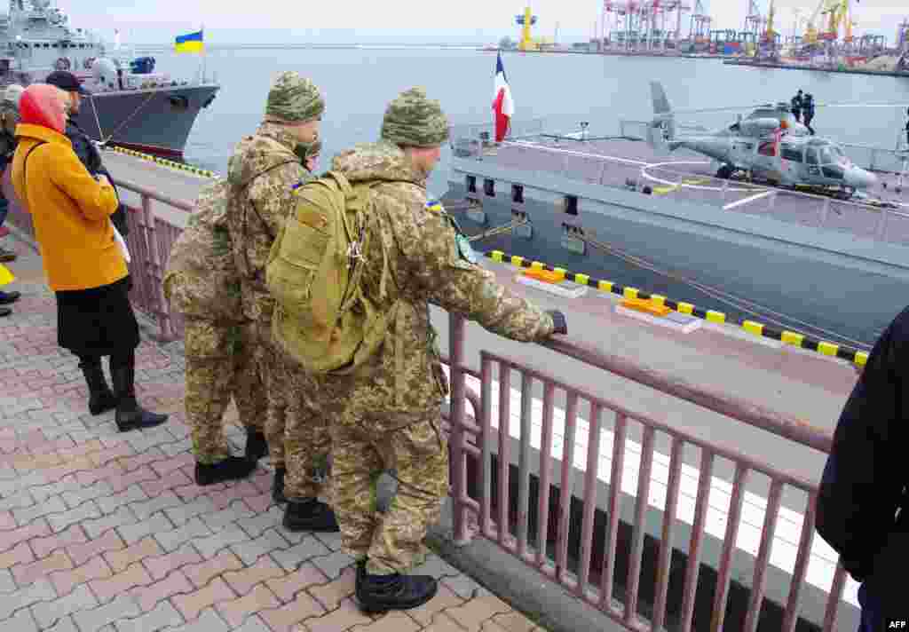 Українські солдати розглядають французький військовий фрегат «Ла Фаєтт», який прибув у порт Одеси з дружнім візитом, 26 березня 2015 року