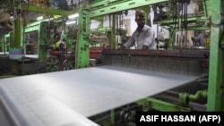A Pakistan textile laborer works on a power loom in Karachi, the financial capital and the largest industrial city of Pakistan.