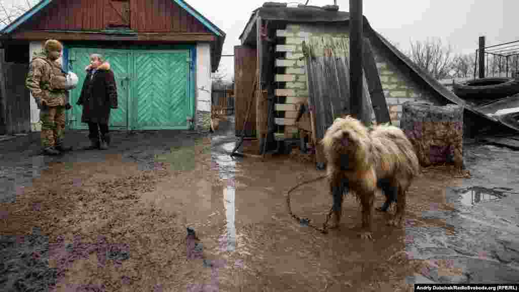 Український військовий розмовляє з жінкою на околиці Золотого-4 після атаки і потужного артобстрілу гібридними силами Росії позицій ЗСУ 18 лютого. Фото – Золоте-4, 19 лютого 2020 року БІЛЬШЕ ПРО ЦЕ