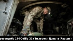 Військовослужбовець 24-ї ОМБр імені короля Данила несе снаряд до САУ M109, Донецька область, 14 червня 2025 року