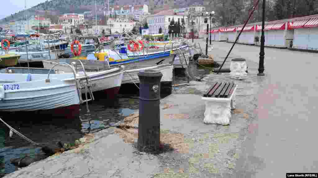 Лодки пришвартованы у набережной. На переднем плане – корабельная пушка времен крымской войны, забетонированная в набережную