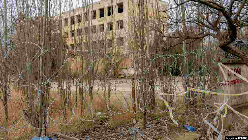 Брошенное здание по соседству с бромным заводом по всему периметру ограждено «егозой»