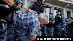 Полицейские задерживают участника митинга, призывающего кандидатов от оппозиции зарегистрироваться для выборов в Московскую городскую думу, Москва, Россия, 27 июля 2019 года.