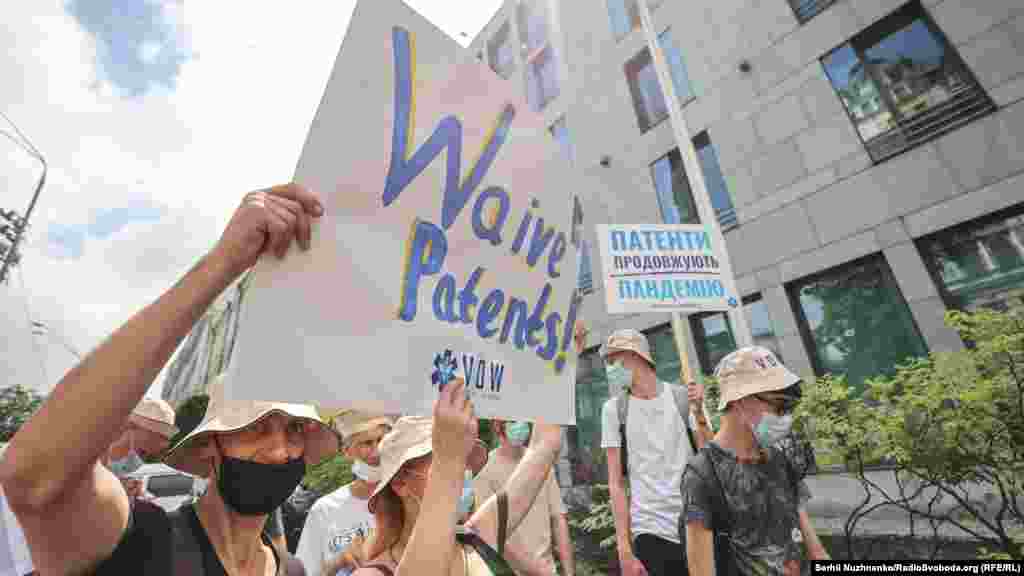 Актвіст тримає у руках плакат: «Відмовтеся від патентів»