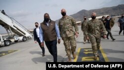 U.S. Defense Secretary Lloyd Austin (second left) walks with U.S. military personnel upon arriving for an unannounced visit to Kabul on March 21 to assess the security situation.
