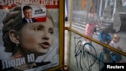 Ілюстраційне фото. Реклама обкладинки журналу з кандидатом в президенти Юлією Тимошенко та виборчого плаката кандидата в президенти Петра Порошенка на наступний день після президентських виборів в Києві, 26 травня 2014 року