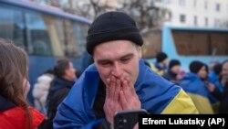 Ukrajinski vojnik razgovara telefonom sa svojim rođacima nakon povratka iz zarobljeništva