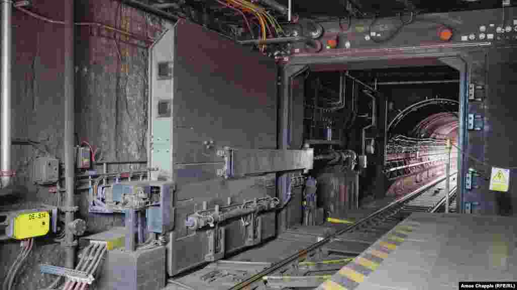 Blindirana vrata unutar metro stanice Dejvicka u Pragu fotografisana u momentu dok se približava voz metroa. Većina OSM-a izgrađena je tokom Hladnog rata, ali ažurirane verzije sistema iz sovjetskog doba ugrađene su u neke novije stanice podzemne željeznice koje je izgradila nezavisna Češka.    