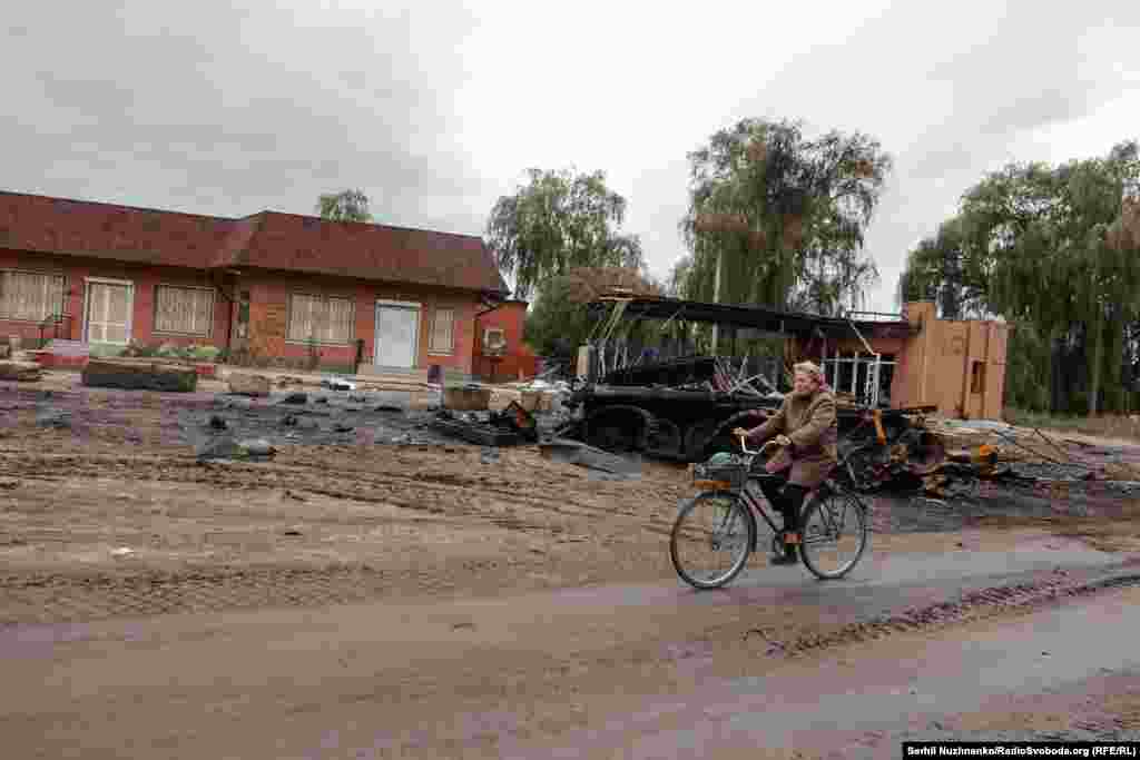 Місцева жителька проїжджає повз знищену російську техніку, вересень 2022 року / Праворуч: початок жовтня 2024-го. Зараз у місті відновлене міське сполучення