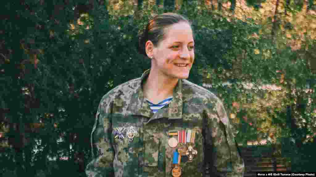 Юлія «Валькірія» Толопа, батальйон «Айдар» / батальйон «Донбас-Україна»/ 58-а окрема механізована бригада «З жорстких моментів – підрив у Жовтому. Наша машина тоді підірвалась на фугасі. Тоді в нас стояло завдання утримати висоту. Нас було осіб 60–100. Командир узяв мене і ще двох бійців – ми мали тримати оборону перехрестя. Сіли в машину… і буквально хвилин через 15 я просто лежу з розплющеними очима й не розумію, що взагалі сталося. Ми наїхали на фугас – і стався вибух. Командира і водія просто розірвало на шматки, бо вибух припав на передню частину машини. Мене викинуло, і я дивом залишилася жива. Обійшлося лиш контузією і переломами ребер. Це найстрашніше, що сталося саме зі мною за час війни. Це було 12 липня 2014 року».
