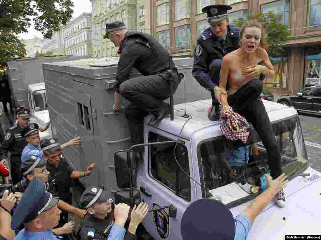 Поліцейські затримують Оксану Шачко на даху поліцейської автівки для перевезення затриманих під час мітингу біля одного з київських судів. Femen виступили проти переслідування, як вони стверджували, прем&rsquo;єр-міністра України Юлії Тимошенко. 2011 рік