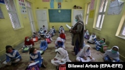Students attend a class in Peshawar during the first day of primary school after the resumption of classes on September 30.