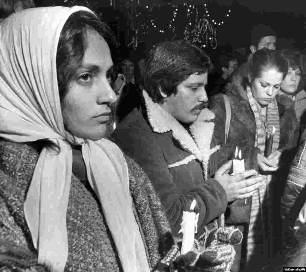 Некоторые из собравшихся на траурный вечер в Boston Common, несут зажженые свечи. Многие из них исполнили песни Леннона и The Beatles, 10 декабря 1980 года