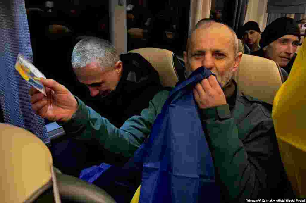 Звільнений з російського полону український військовий цілує прапор України  