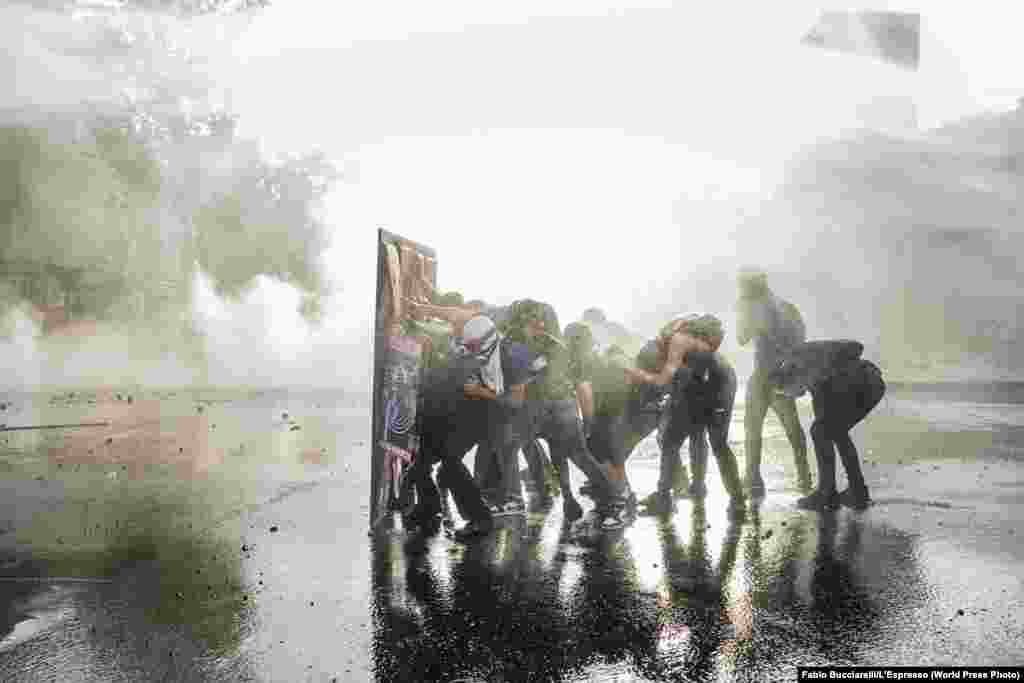 Демонстранти захищаються щитом від водометів під час сутичок у Сантьяго, Чилі, 28 листопада 2019 року. Друге місце в категорії «Загальні новини», історії – Фабіо Буччареллі, L'Espresso