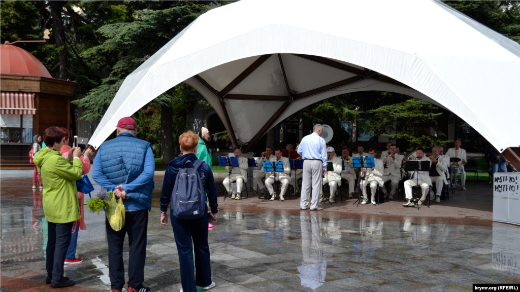 В этом году 25 сентября через южный берег Крыма проходил холодный атмосферный фронт, который принес понижение температуры и дожди. С утра на набережной Ялты городской духовой оркестр в рамках фестиваля «Белый цветок» играл под навесом 