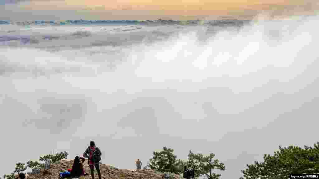 Туристы на краю туманного обрыва. Где-то там, внизу, – самый маленький город Крыма Алупка