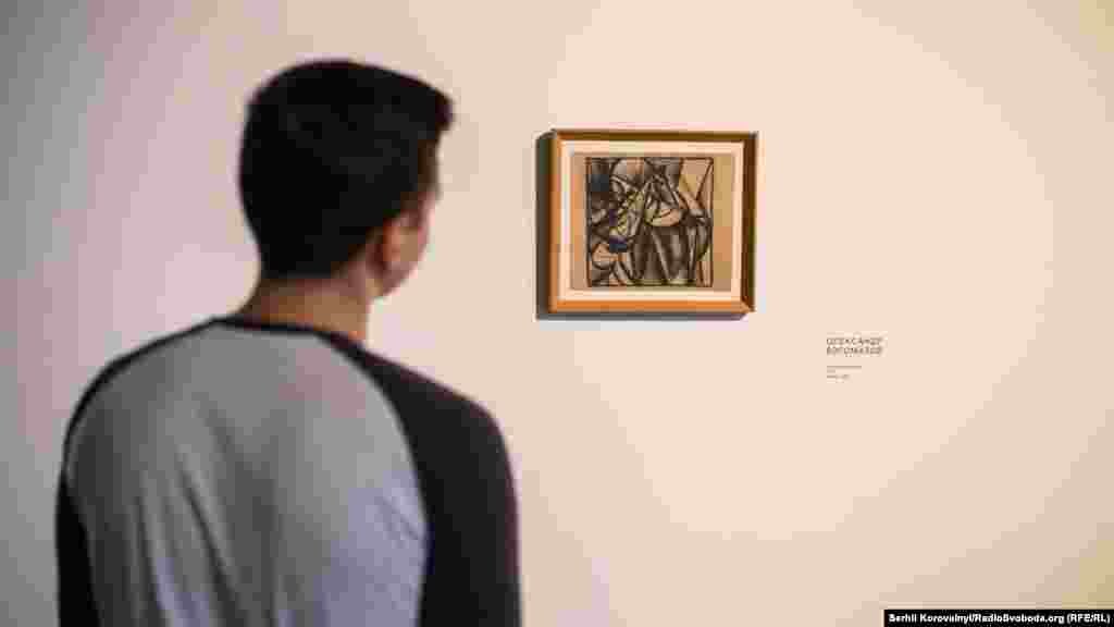 Хлопець розглядає картину Олександра Богомазова «Портрет жінки»