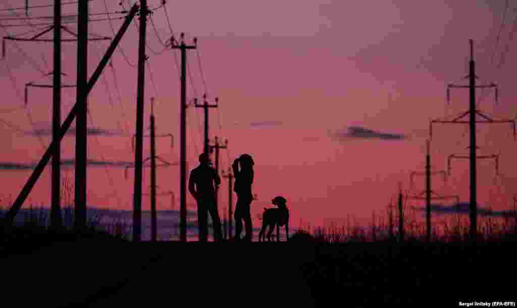 Подружжя з собакою на прогулянці у столиці Росії в період суворої ізоляції у зв'язку коронавірусною пандемією. (epa-EFE/Serrgei Ilnitsky)