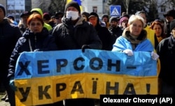 Архівна світлина. Люди стоять перед військовими Росії під час мітингу проти російської окупації. Херсон, 20 березня 2022 року