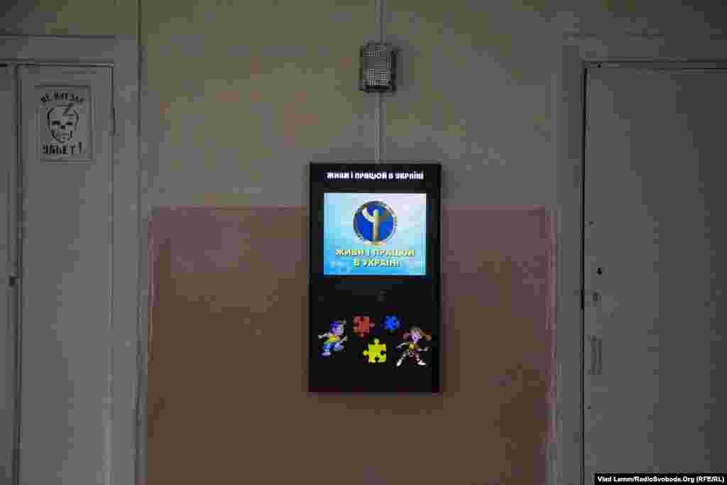 Електронний стенд для вибору професії випускниками з написом «Живи і працюй в Україні», що знаходиться у пустій будівлі