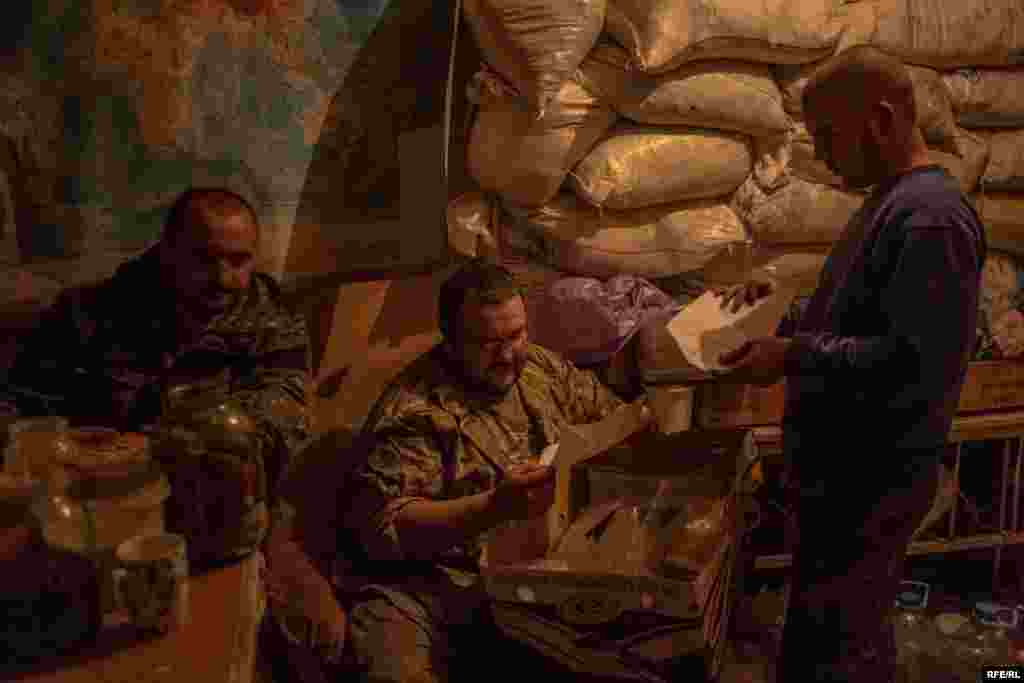 «Тунец» и двое других бойцов открывают письма от украинских детей. Письма доставили волонтеры вместе с остальными пакетами. Дети вдохновляют их не прекращать борьбу