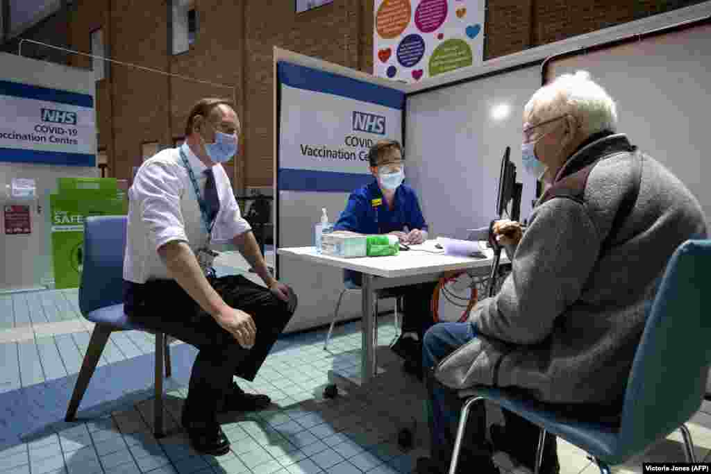 Саймон Стівенс (ліворуч), виконавчий директор NHS (Національна служба охорони здоров’я Сполученого Королівства), розмовляє з пацієнтом, який прибув у центр вакцинації, щоб отримати дозу вакцини Pfizer/BioNTech Covid-19 у лікарні Гая. Лондон, Велика Британія, 8 грудня 2020 року