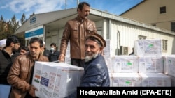 Afghan healthcare workers unload the first shipment of COVID-19 vaccines donated by the Indian government at the Kabul airport on February 7.