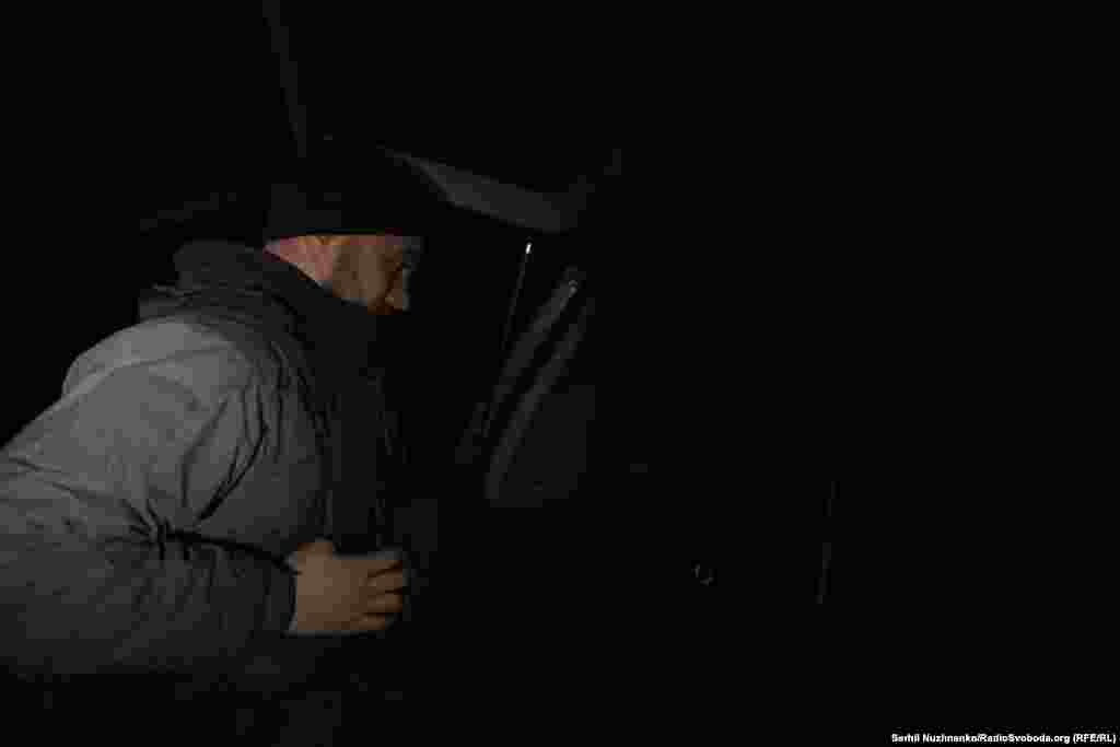 Через добу покидаємо позиції. На цьому ж місці, де минулої ночі одягнули бронежилети, знімаємо їх. Темна пора доби дає більше шансів на безпечний виїзд. На фото: військовий кореспондент Радіо Свобода Марʼян Кушнір знімає бронежилет