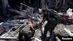 Бойовики угруповання «ДНР» розглядають уламки біля пошкодженої будівлі, Донецьк, 6 серпня 2014 року