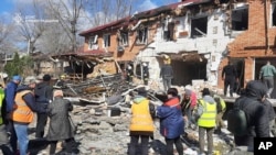 Жителі розчищають завали після атаки російського безпілотника в Кропивницькому, Кіровоградська область, Україна, 20 березня 2025 року