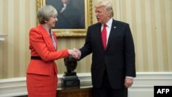 Прем'єр-міністр Великобританії Тереза Мей і президент США Дональд Трамп тиснуть руку одне одному (позаду бюст колишнього британського прем'єра Уїнстона Черчилля) в Овальному кабінеті Білого дому, Вашингтон, 27 січня 2017 року
