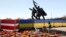 Памятник советским солдатам в Риге, окруженный забором в цветах латвийского и украинского флагов, в мае 2022 года, за три месяца до того, как он был снесен