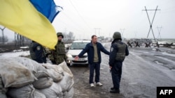 Українські військові перевіряють документи у водія на КПП в Кураховому. Січень 2015 року