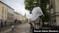 Cnатуя Діани з медичною маскою на обличчі на нетипово порожній площі Ринок у Львові, травень 2020 року