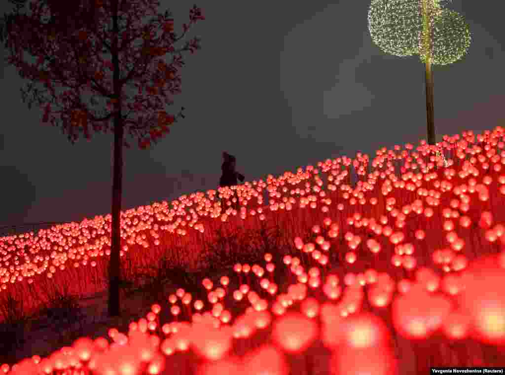 Женщина проходит рядом с украшениями, установленными к новогодним и рождественским праздникам в парке «Зарядье» в Москве, Россия, 30 декабря. (Reuters/Евгения Новоженина)