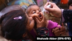 A health worker administers polio vaccine to children during a polio vaccination door-to-door campaign in Karachi on June 7.