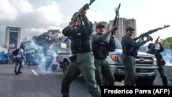 Члени Боліварської національної гвардії, що доєдналися до лідера опозиції Хуана Гуайдо, стріляють у повітря, щоб відлякати силовиків-прибічників президнета Ніколаса Мадуро